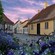 Un pueblo histórico bien conservado, flanqueado de flores, árboles y arquitectura del siglo XIX